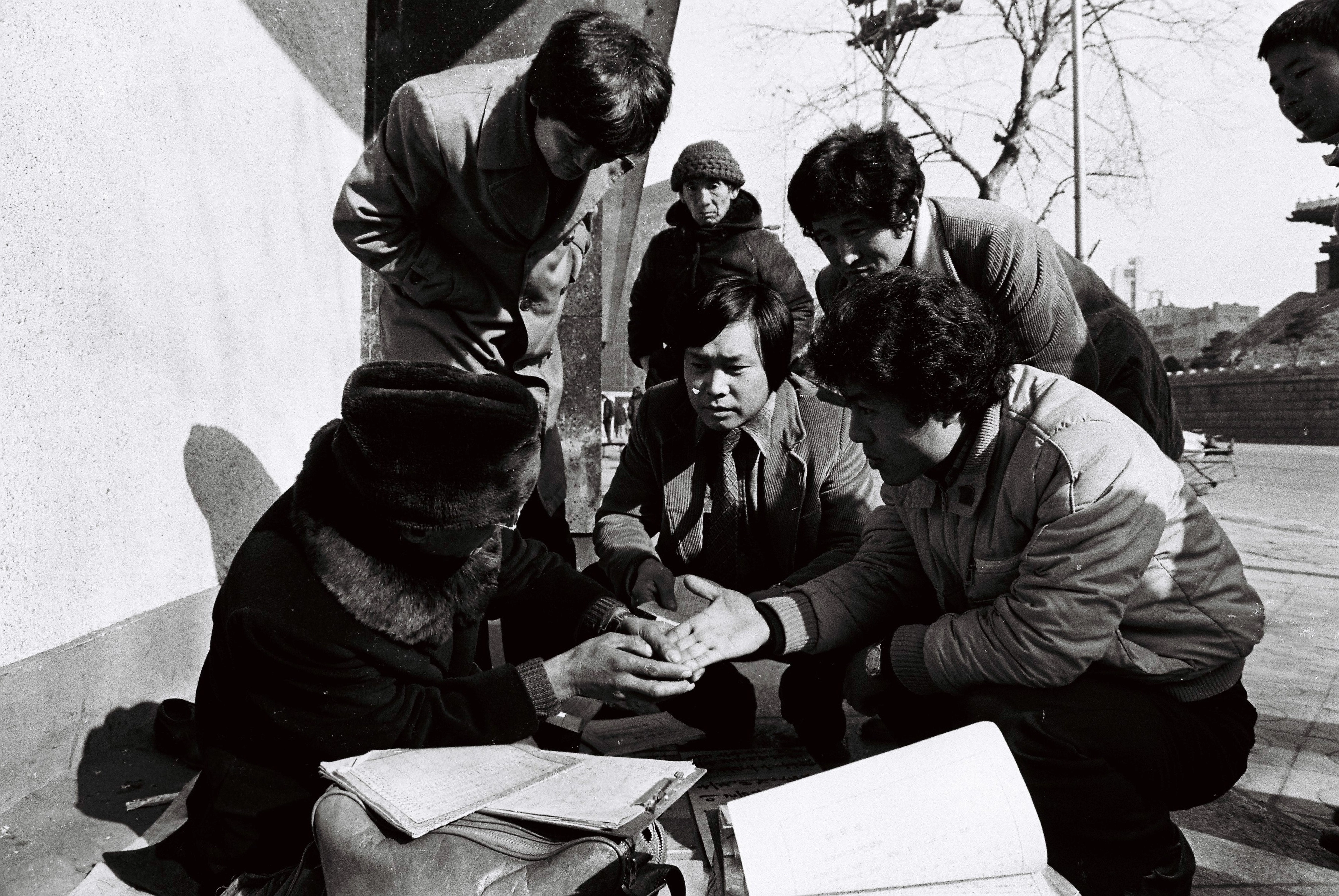 1982년 새해를 맞아 서울 중심가 대로변에서 행인들이 점사로부터 손금과 토정비결을 보고 있다.
서울신문 DB