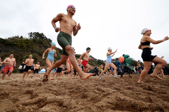 1일 오후 제주 서귀포시 중문색달해변에서 열린 제27회 서귀포 겨울바다 국제펭귄수영대회에서 참가자들이 바다로 뛰어들고 있다. 2026.1.1 연합뉴스