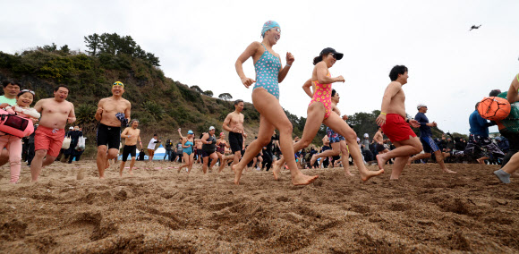 1일 오후 제주 서귀포시 중문색달해변에서 열린 제27회 서귀포 겨울바다 국제펭귄수영대회에서 참가자들이 바다로 뛰어들고 있다. 2026.1.1 연합뉴스