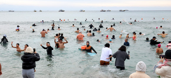 1일 오후 제주 서귀포시 중문색달해변에서 열린 제27회 서귀포 겨울바다 국제펭귄수영대회에서 참가자들이 바다로 뛰어들고 있다. 2026.1.1 연합뉴스