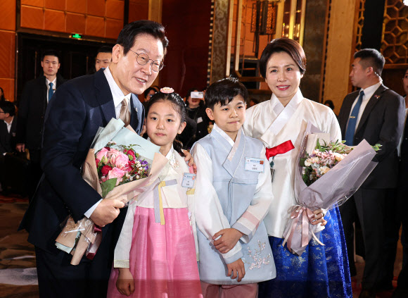 이재명 대통령과 김혜경 여사가 4일 중국 베이징 한 호텔에서 열린 동포 만찬간담회에서 화동과 기념촬영을 하고 있다. 2026.1.4 연합뉴스