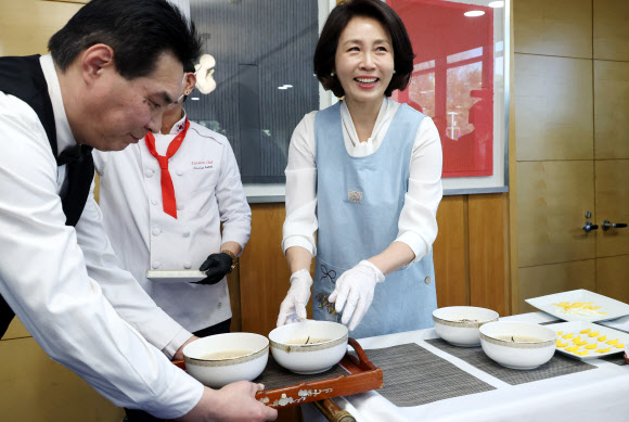 김혜경 여사가 5일 베이징 주한 중국대사관저에서 열린 한중 가교 역할 중국인 여성 초청 한식 오찬 간담회에서 참석자들을 위한 떡국에 고명을 얹어 옮기고 있다. 2026.1.5  연합뉴스