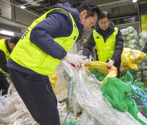 더불어민주당 정청래 대표와 최고위원, 의원들이 7일 서울 송파구 가락동농수산물도매시장 채소2동을 찾아 경매 후 남겨진 쓰레기들을 치우고 있다.  이날 민주당은 새해를 맞이해 ‘국민 곁으로! 현장 속으로!’ 현장 방문을 시작했다. 2026.1.7 연합뉴스