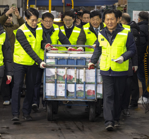 더불어민주당 정청래 대표와 최고위원들이 7일 서울 송파구 가락동농수산물도매시장 중앙청과 내 사과 경매장을 방문해 경매를 마친 사과를 소매인에게 전달할 차량으로 배달하고 있다. 이날 민주당은 새해를 맞이해 ‘국민 곁으로! 현장 속으로!’ 현장 방문을 시작했다. 2026.1.7 연합뉴스