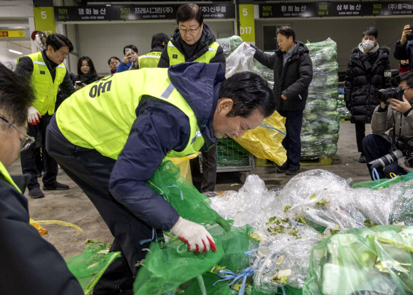 더불어민주당 정청래 대표와 최고위원, 의원들이 7일 서울 송파구 가락동농수산물도매시장 채소2동을 찾아 경매 후 남겨진 쓰레기들을 치우고 있다.  이날 민주당은 새해를 맞이해 ‘국민 곁으로! 현장 속으로!’ 현장 방문을 시작했다. 2026.1.7 연합뉴스