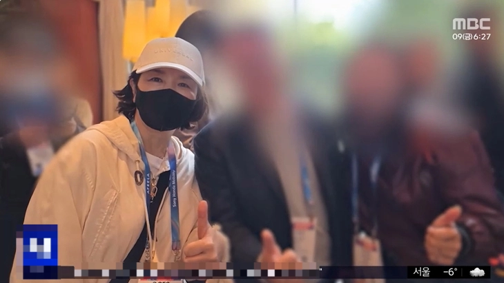 지난 6일(현지시간) 미국 라스베이거스에서 열린 IT·가전 전시회인 CES에서 엄지를 치켜든 채 관계자들과 사진을 찍고 있는 김경 서울시의원. MBC 자료화면 캡쳐