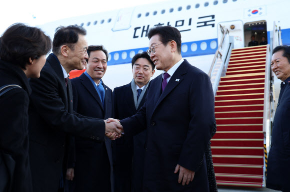 한일 정상회담을 위해 일본 나라현을 방문하는 이재명 대통령이 13일 성남 서울공항에서 환송나온 마츠오 히로타카 주한일본대사관 총괄공사와 인사하고 있다.  그 뒤는 우상호 정무수석, 강훈식 대통령비서실장, 더불어민주당 정청래 대표. 2026.1.13 연합뉴스