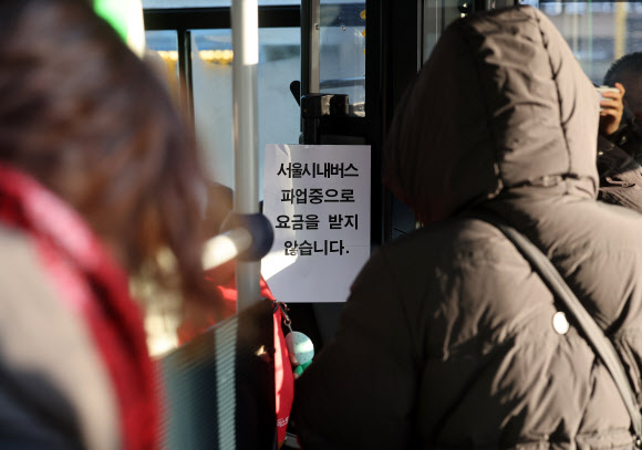 서울 시내버스 노동조합이 첫차부터 무기한 전면파업에 돌입한 13일 서울 홍제역 인근에서 운행 중인 한 버스에 ‘시내버스 파업중으로 요금을 받지 않습니다’라는 안내문이 붙어 있다. 2026.1.13 연합뉴스