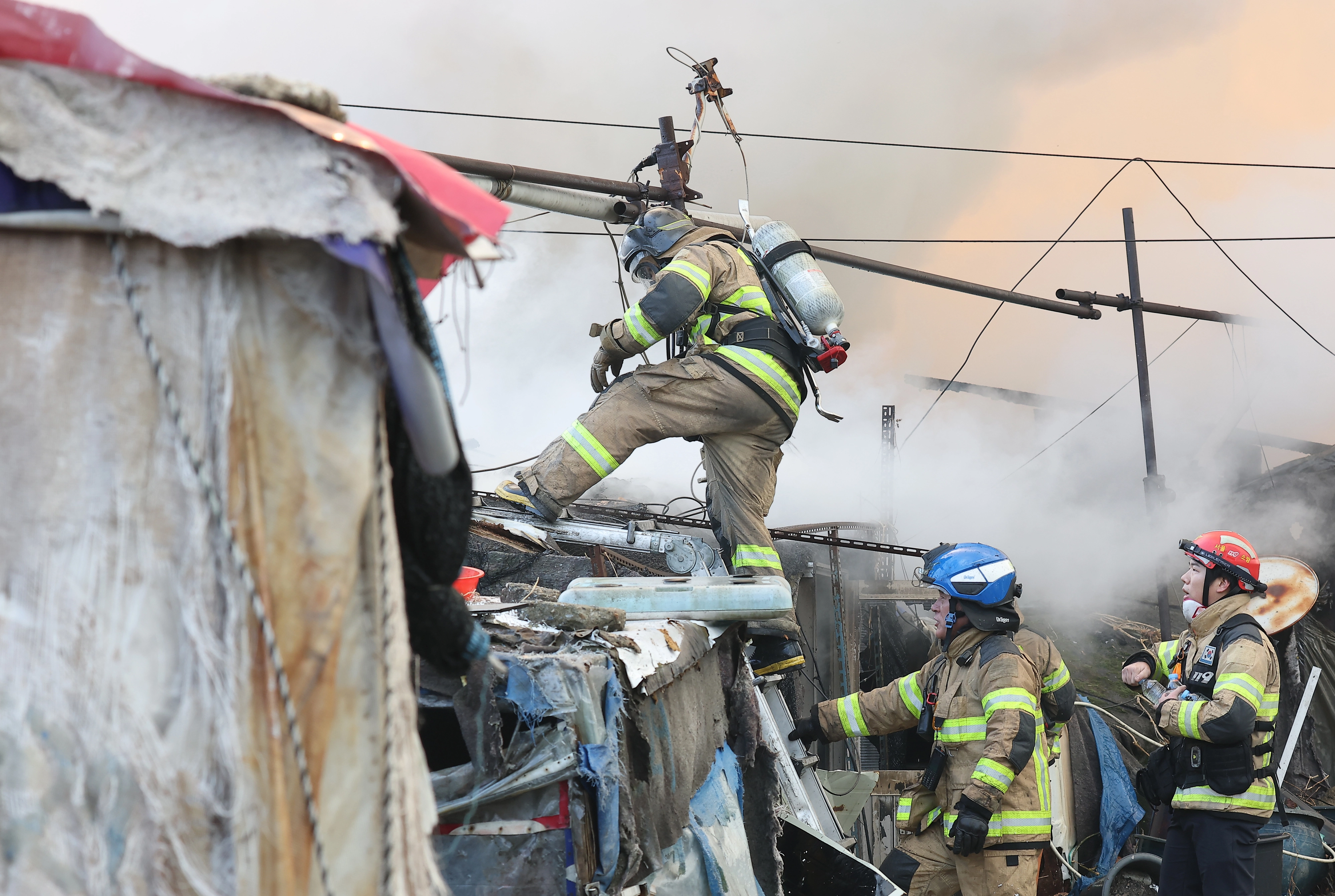 지난 16일 서울 강남구 개포동 구룡마을에서 소방관들이 잔불을 진압하고 있다. 연합뉴스