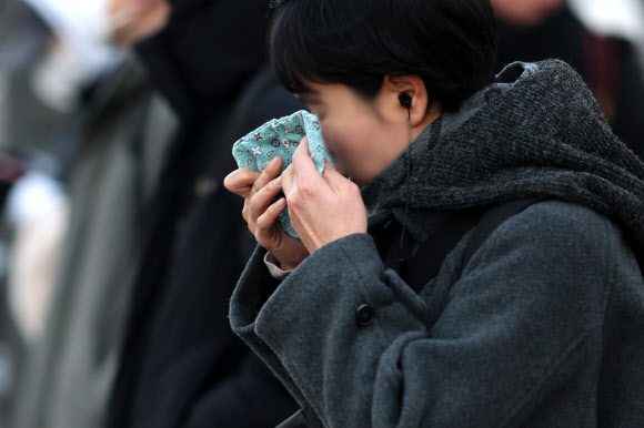 한파특보가 발령된 20일 서울 세종대로 사거리에서 한 시민이 손수건으로 얼굴을 닦고 있다. 2026.1.20 연합뉴스