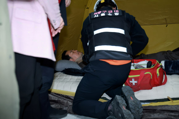21일 국회 로텐더홀 단식 농성장에서 구급대원이 통일교·공천헌금 ‘쌍특검’ 수용을 요구하며 이레째 단식 중인 국민의힘 장동혁 대표의 바이탈을 체크하고 있다. 2026.1.21  연합뉴스