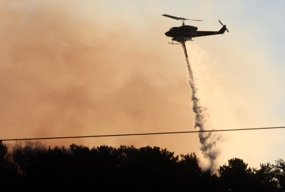 22일 오전 부산 기장군 기장읍 산불 현장에 투입된 헬기가 진화작업을 벌이고 있다. 2026.1.22 연합뉴스