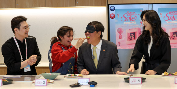 최휘영 문화체육관광부 장관이 22일 서울 영등포구 더현대 서울 문화센터에서 열린 코리아그랜드세일의 체험행사 ‘케이-소스 활용 한식 쿠킹클래스’에서 외국인 관광객이 만든 쌈밥을 맛보고 있다. 2026.1.22. 문화체육관광부 제공