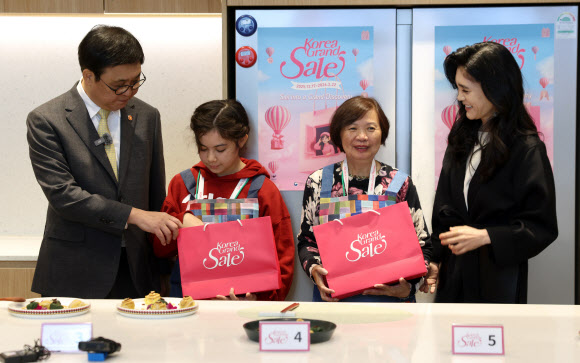 최휘영 문화체육관광부 장관과 이부진 한국방문의해위원회 위원장이 22일 서울 영등포구 더현대 서울 문화센터에서 열린 코리아그랜드세일의 체험행사 ‘케이-소스 활용 한식 쿠킹클래스’에서 외국인 관광객에게 선물을 전달하고 있다. 2026.1.22. 문화체육관광부 제공