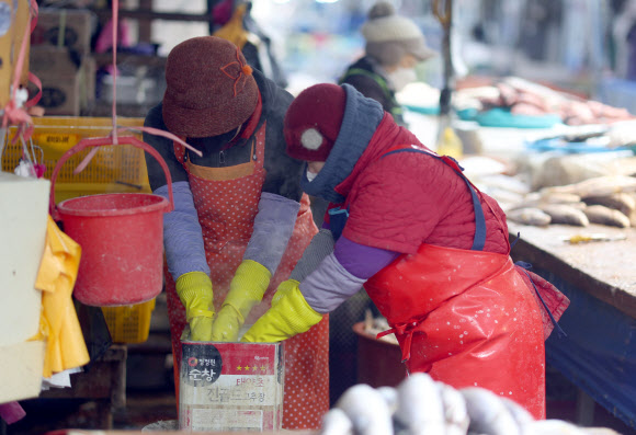 언 손 녹이는 상인