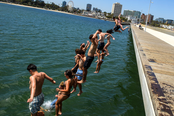젊은이들이 27일(현지시간) 호주 멜버른의 세인트 킬다 부두에서 뛰어내리고 있다. 빅토리아주 주민들은 거의 20년 만에 가장 심각한 폭염에 시달리고 있다. EPA 연합뉴스