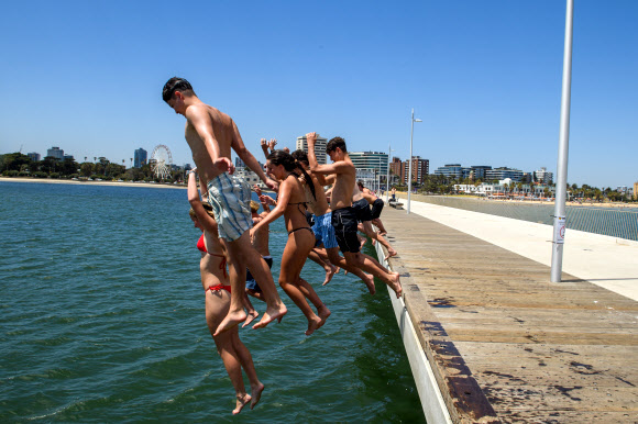 젊은이들이 27일(현지시간) 호주 멜버른의 세인트 킬다 부두에서 뛰어내리고 있다. 빅토리아주 주민들은 거의 20년 만에 가장 심각한 폭염에 시달리고 있다. EPA 연합뉴스