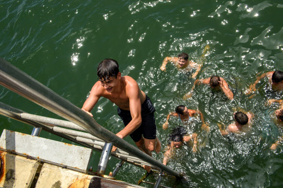 젊은이들이 27일(현지시간) 호주 멜버른의 세인트 킬다 부두에서 뛰어내리고 있다. 빅토리아주 주민들은 거의 20년 만에 가장 심각한 폭염에 시달리고 있다. EPA 연합뉴스