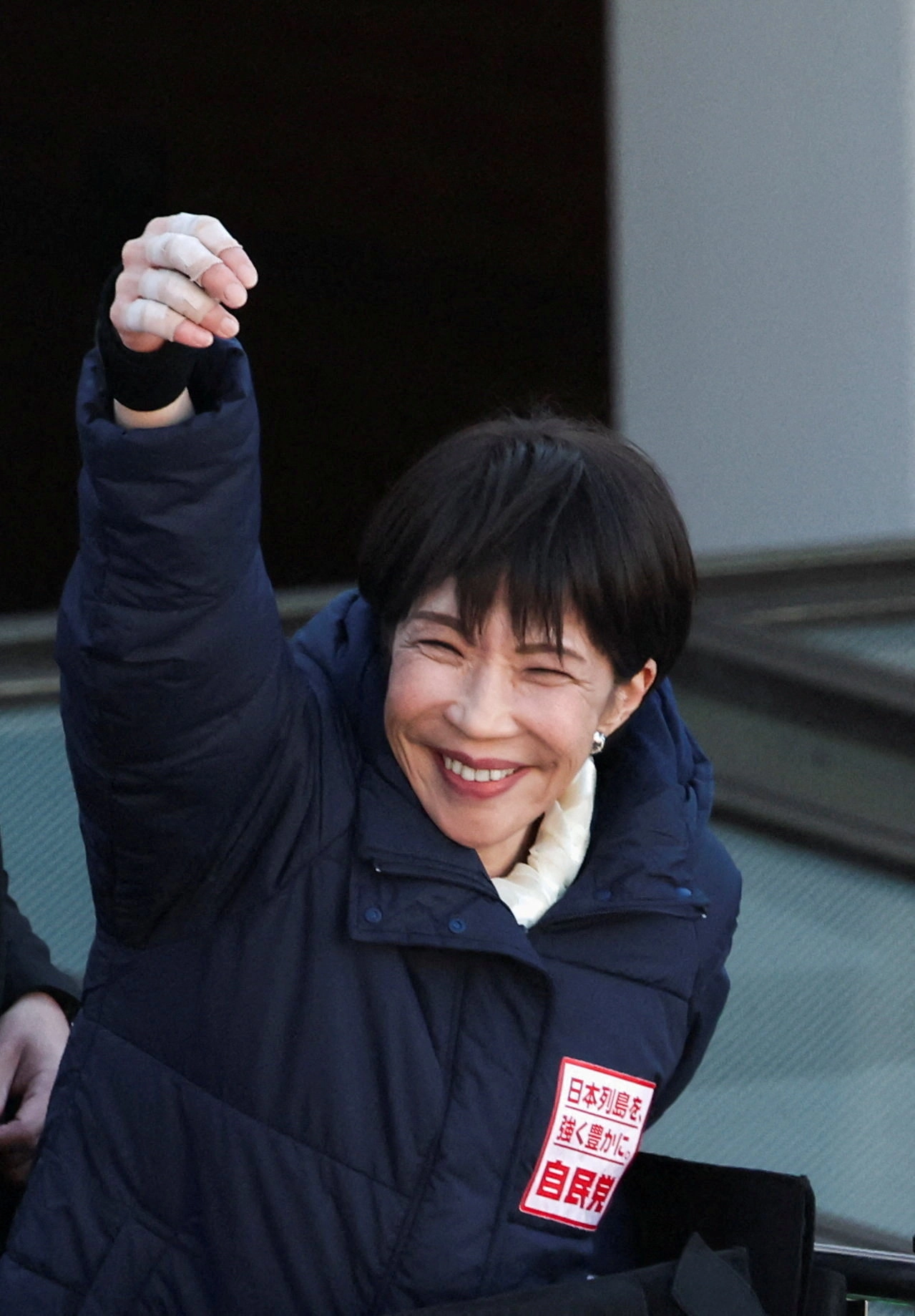 3일 유세 연단에 오른 다카이치 총리가 시민들의 연호에 손을 들어 화답하고 있다. 오른손 손가락에 관절염 치료를 위한 의료용 테이프가 감겨 있다. 
사이타마 로이터 연합뉴스