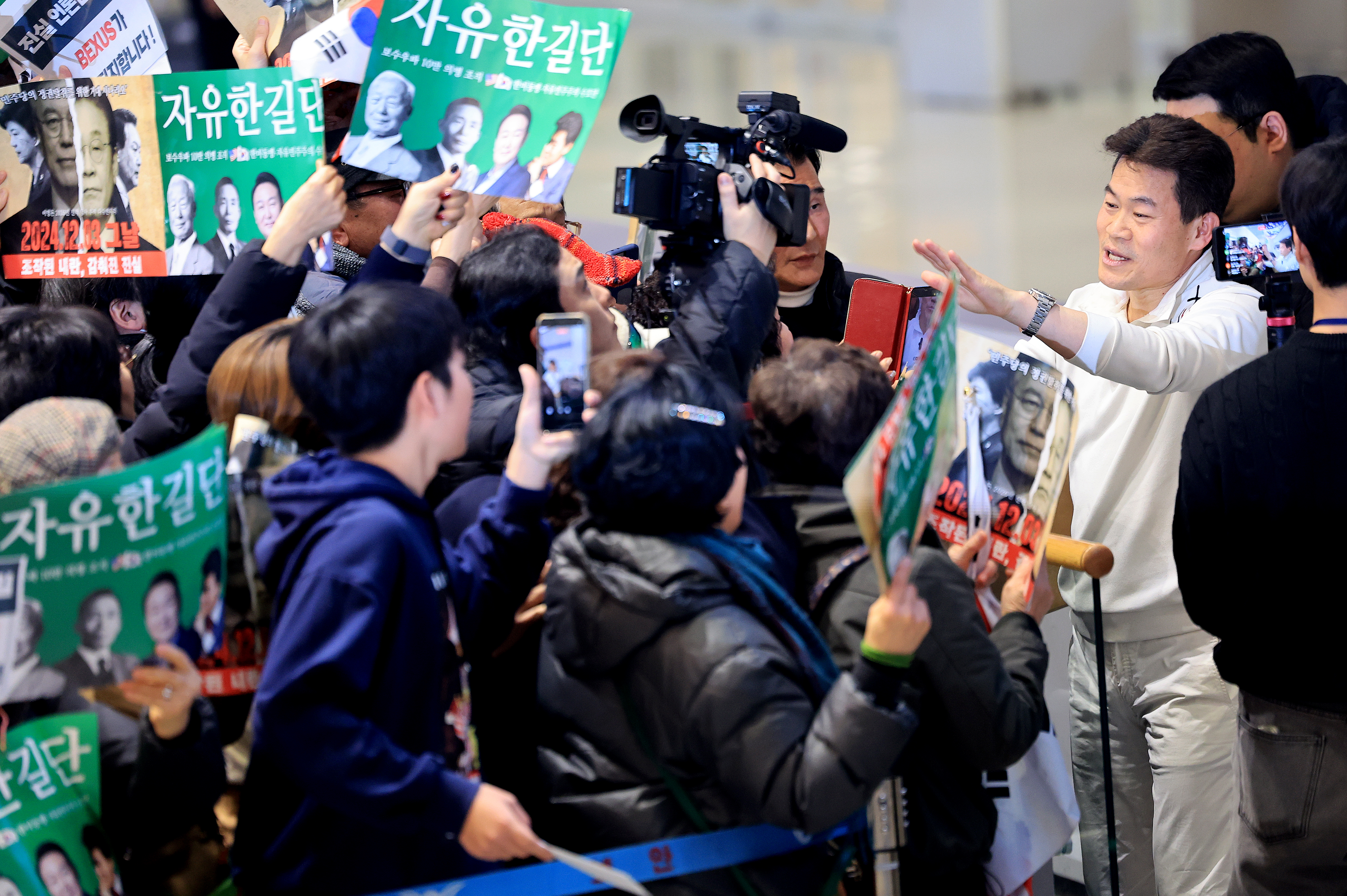 전한길 전 한국사 강사가 3일 인천국제공항 제2여객터미널로 귀국해 지지자들을 향해 손을 흔들고 있다. 2026.2.3. 뉴스1