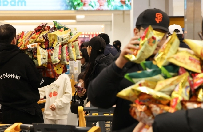 1일 서울 영등포구 이마트 영등포점에서 시민들이 과자를 들고 계산대 앞에서 대기하고 있다. 이마트는 지난달 29일부터 2만5000원을 내고 지정된 박스에 과자를 무제한 담을 수 있는 행사를 열고 있다. 2026.2.1 연합뉴스