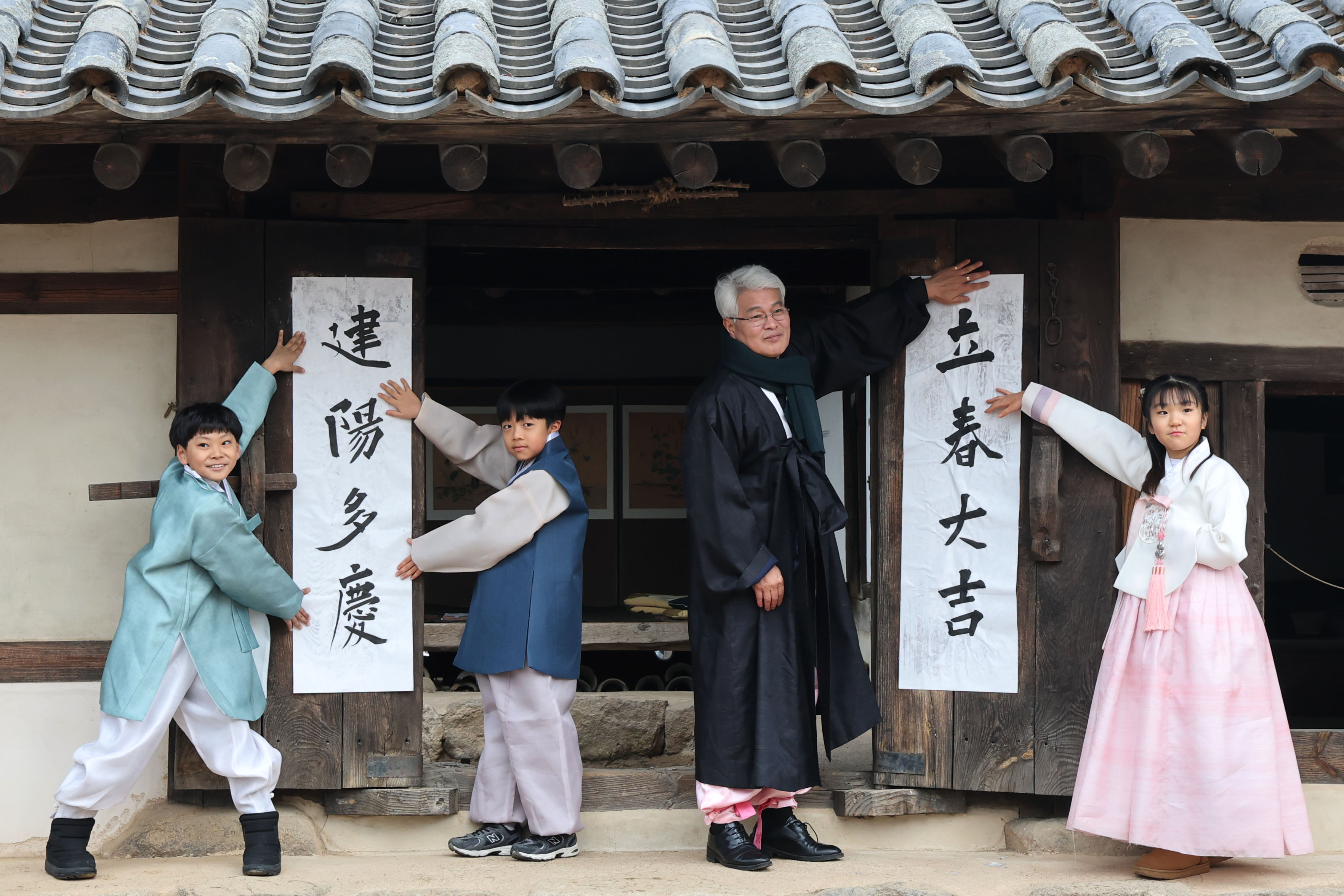 봄의 시작을 알리는 입춘(立春)인 4일 서울 종로구 삼청동 국립민속박물관내 전통한옥인 오촌댁 대문에 어린이들이 ‘입춘대길(立春大吉)’과 ‘건양다경(建陽多慶)’ 글귀를 담은 입춘첩을 붙이고 있다. 입춘첩은 봄의 희망을 담아 한 해 동안 길한 운과 경사스러움이 가득하기를 기원하고 풍년을 기원하는 세시풍속으로 대문이나 문설주에 붙인다.  2026.2.4. 뉴스1