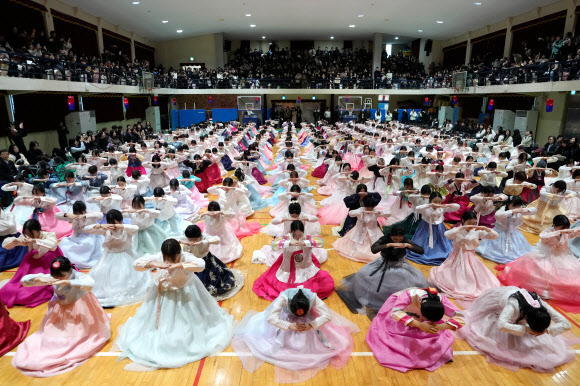 전통 의상을 입은 고등학생들이 5일(현지시간) 대한민국 서울 동명여자고등학교에서 합동 졸업식 및 성인식에서 절을 하고 있다. AP