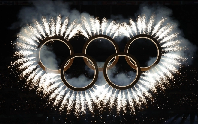 6일 오후(현지시간) 밀라노 산시로 올림픽 스타디움에서 열린 2026 밀라노·코르티나담페초 동계올림픽대회 개회식에서 두 도시의 결합을 상징하는 ‘도시와 산’을 주제로 공연 중 오륜기 로고 형태 조형물에서 불꽃이 터지고 있다. 2026.2.7 뉴스1