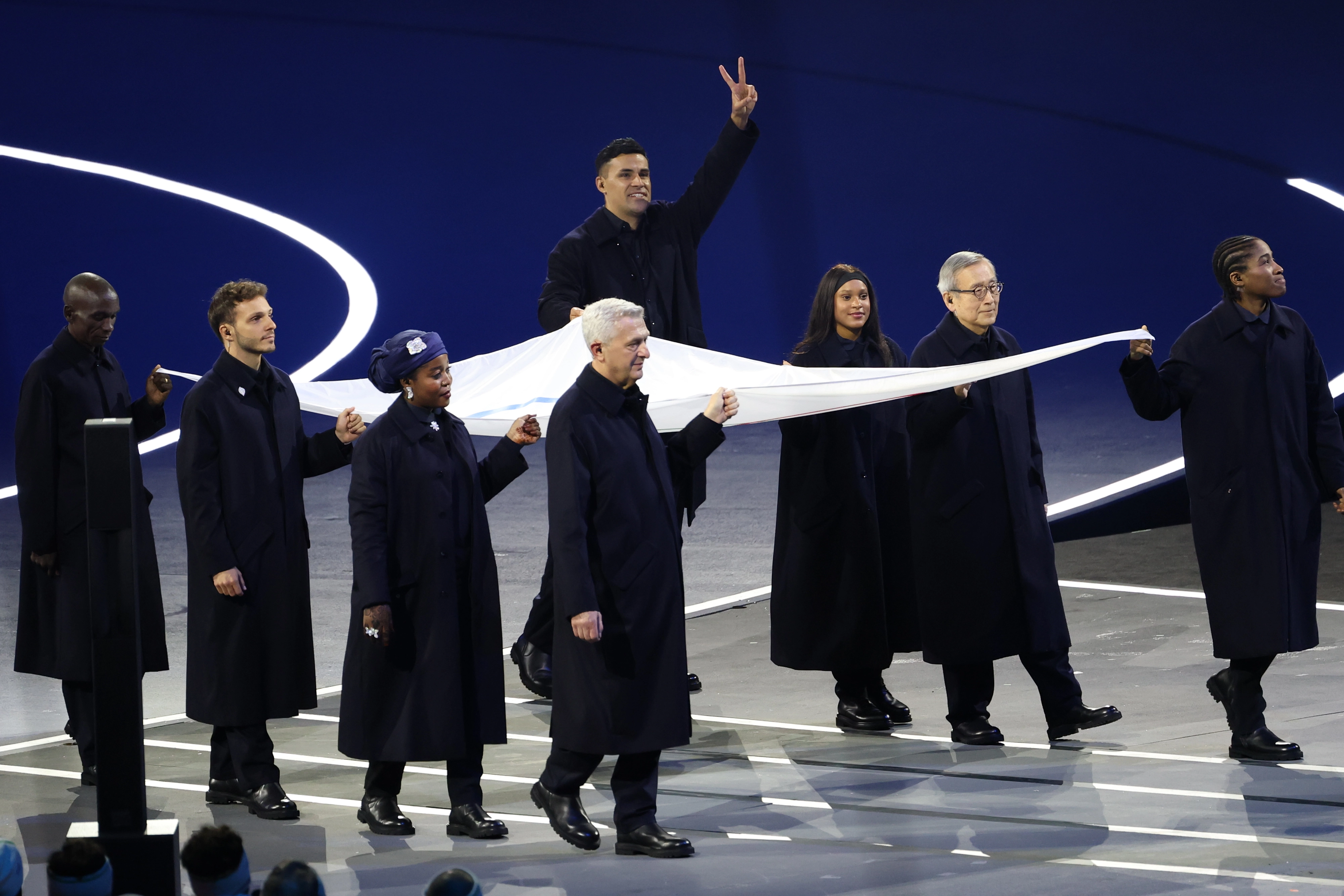 6일(현지시간) 이탈리아 밀라노 산시로 스타디움에서 열린 2026 밀라노-코르티나담페초 동계올림픽 개회식. 2018 평창 동계 올림픽을 비롯해 세 차례 올림픽 개회식에서 웃통을 벗고 나와 화제를 모았던 ‘통가 근육맨’ 피타 타우파토푸아 등 기수들이 오륜기를 들고 입장하고 있다. 2026.2.7 연합뉴스