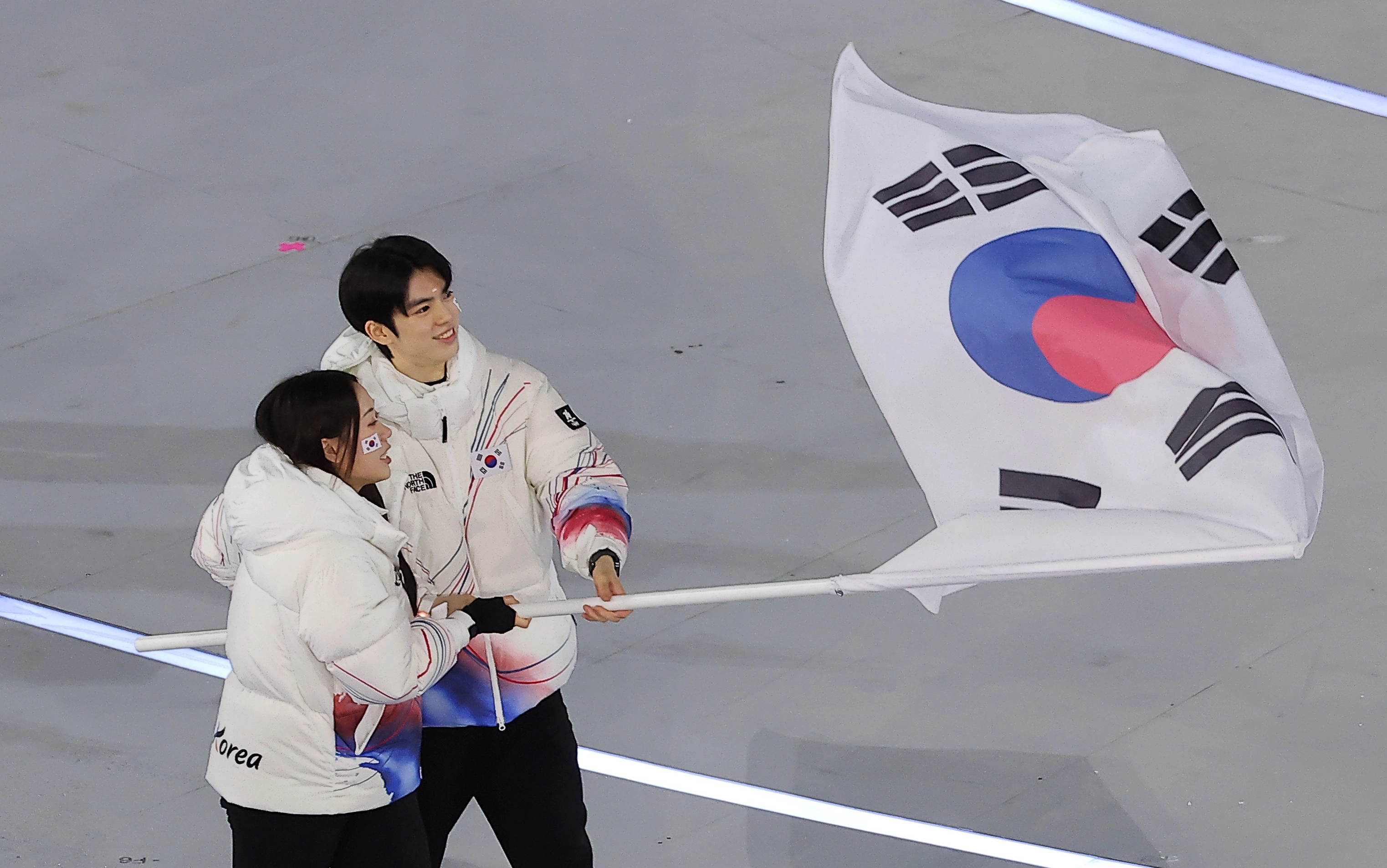차준환·박지우, 자랑스러운 기수  대한민국 선수단 기수 차준환(피겨 스케이팅)과 박지우(스피드 스케이팅)가 6일 오후(현지시간) 이탈리아 밀라노 산시로 올림픽 스타디움에서 열린 2026 밀라노·코르티나담페초 동계올림픽대회 개회식에서 선수단을 이끌고 입장하고 있다. 2026.2.7 뉴스1