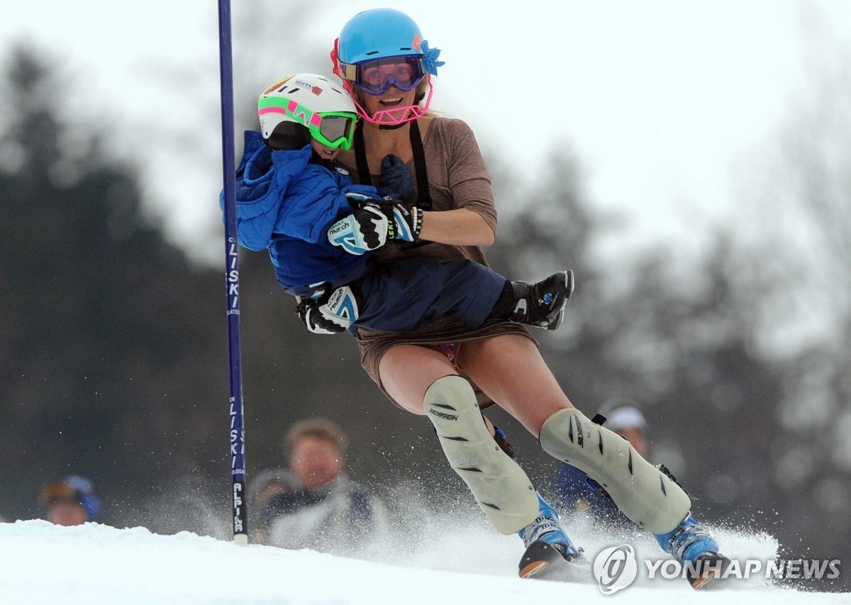 멕시코 알파인 스키 국가대표 사라 슐레퍼가 2011년 은퇴 경기에서 아들인 라시 각시올라를 안고 설원을 내려가고 있다. EPA 연합뉴스
