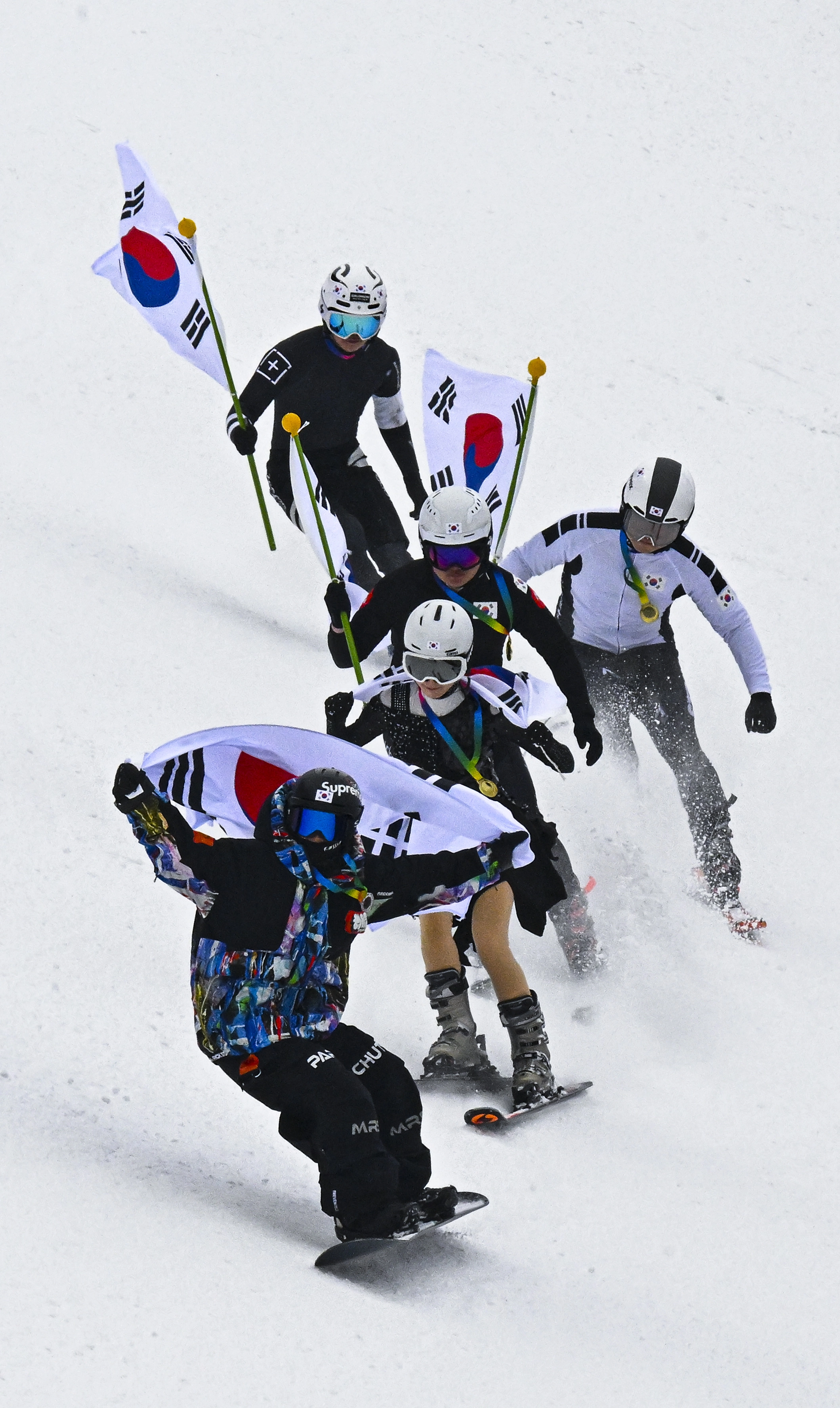 스키어들이 10일 경기 광주시 곤지암리조트 스키장에서 쇼트트랙, 피겨 등의 복장을 차려입고 태극기를 든 채 동계올림픽 국가대표를 응원하는 퍼포먼스를 하고 있다. 2026.2.10 이지훈 기자