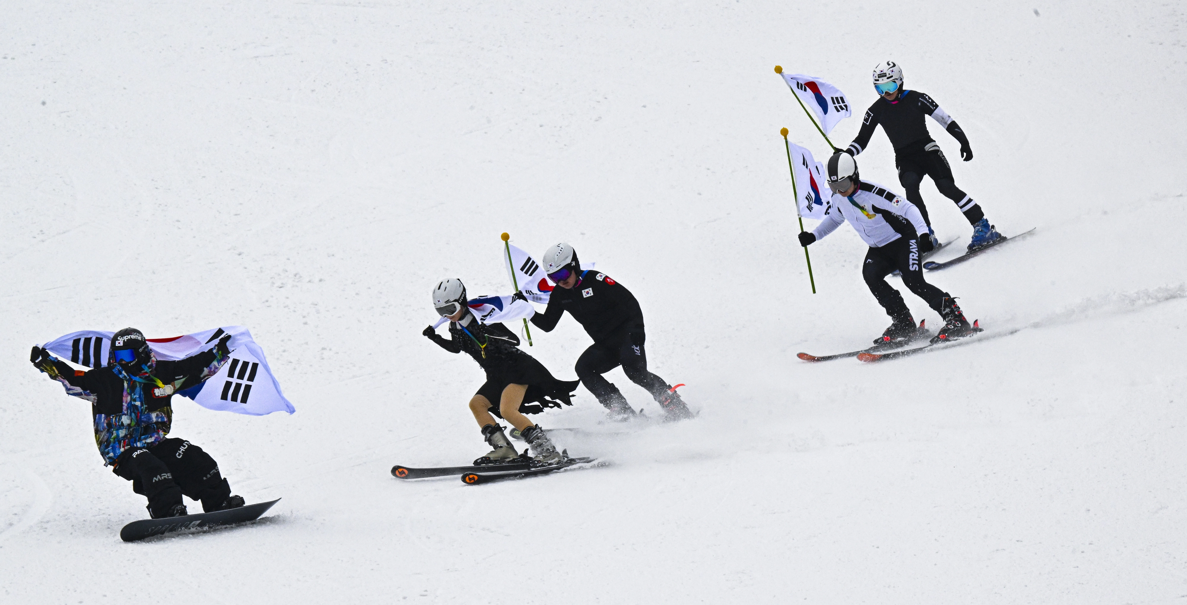 스키어들이 10일 경기 광주시 곤지암리조트 스키장에서 쇼트트랙, 피겨 등 동계스포츠 복장을 차려입고 태극기를 든 채 설원을 활주하고 있다. 2026.2.10 이지훈 기자