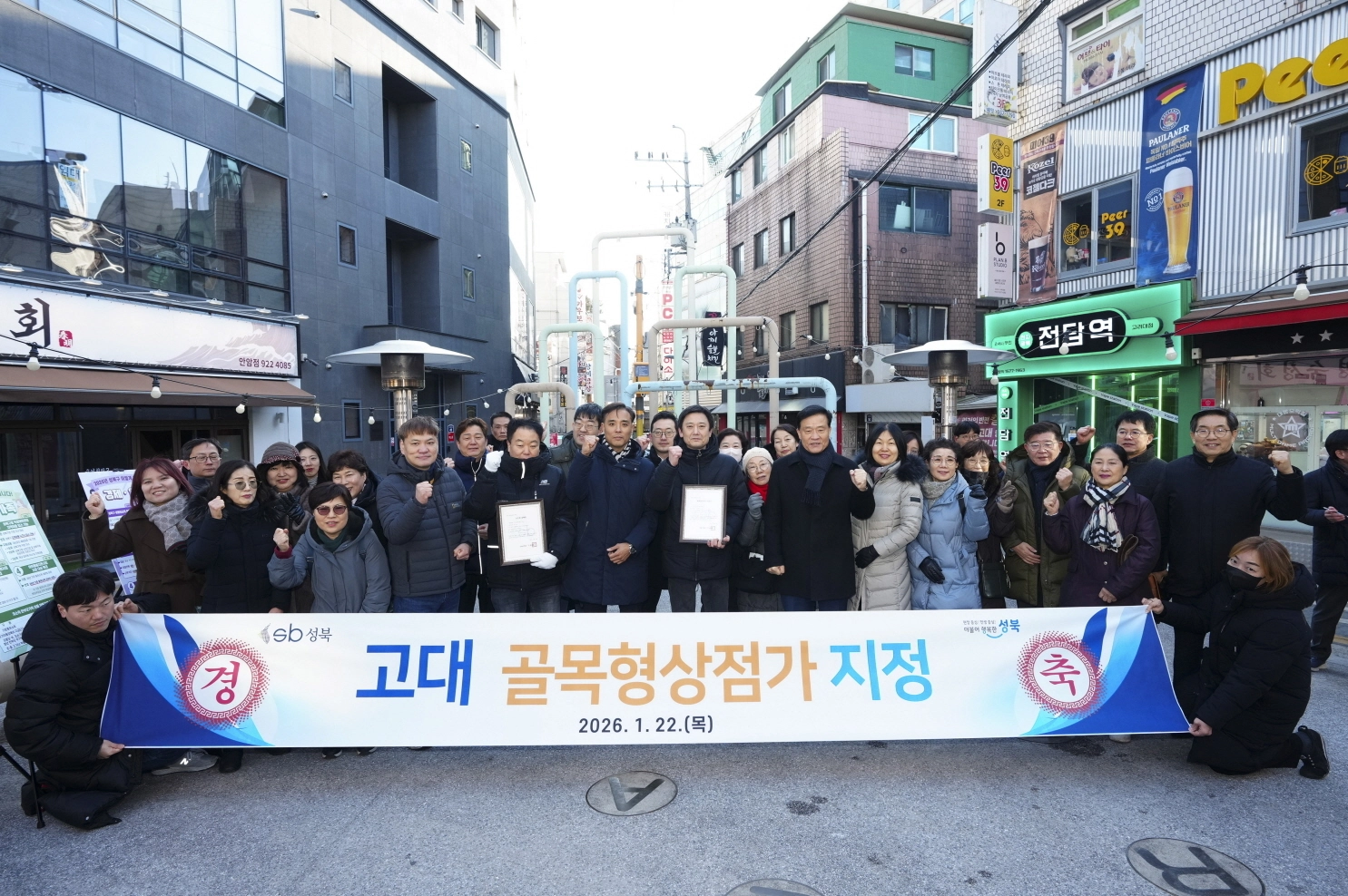이승로(앞줄 오른쪽 여섯 번째) 구청장이 ‘고대 골목형상점가’ 지정을 축하하며 관계자들과 기념 촬영을 하고 있다. 성북구 제공