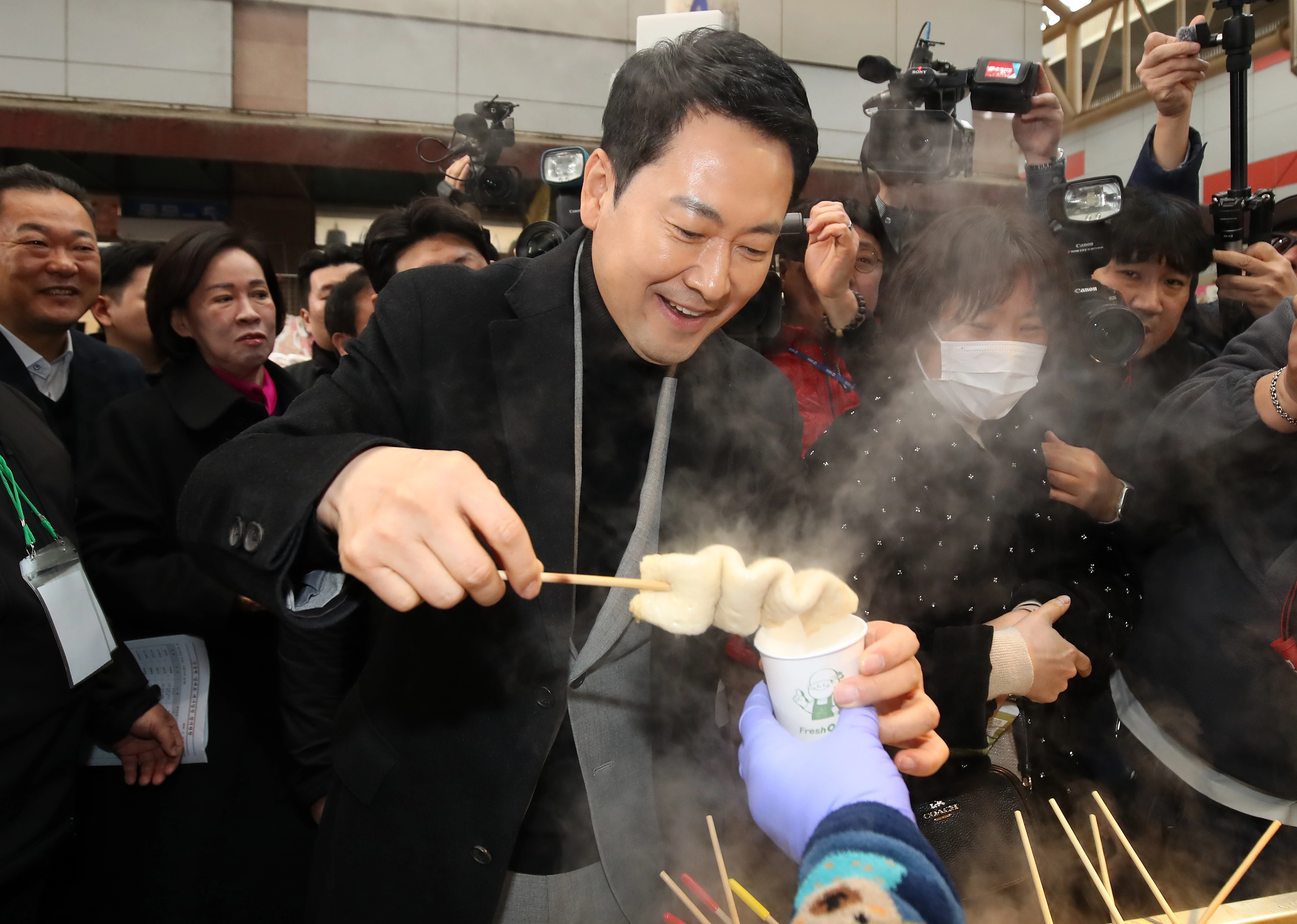 장동혁 국민의힘 대표가 11일 대구 중구 서문시장 상인회 관계자들과 간담회를 한 뒤 어묵을 먹는 모습.
대구 뉴스1