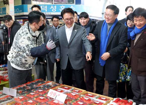 김민석 국무총리가 12일 설을 앞두고 물가를 점검하기 위해 청주 육거리종합시장을 찾아 딸기를 살펴보고 있다. 2026.2.12 연합뉴스