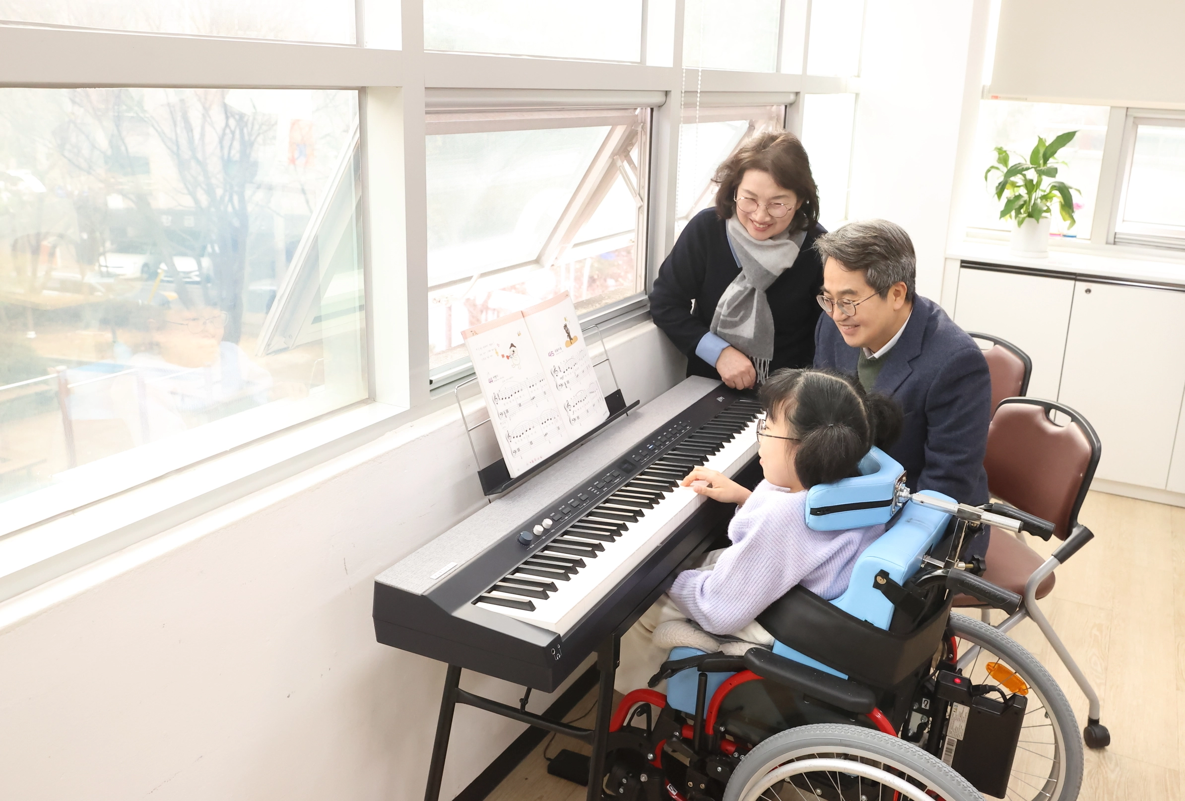 김동연 경기도지사와 부인 정우영 여사가 14일 오후 사회복지시설인 양자의 집을 찾아 장애 소녀의 피아노 연주를 지켜보고 있다. (경기도 제공)