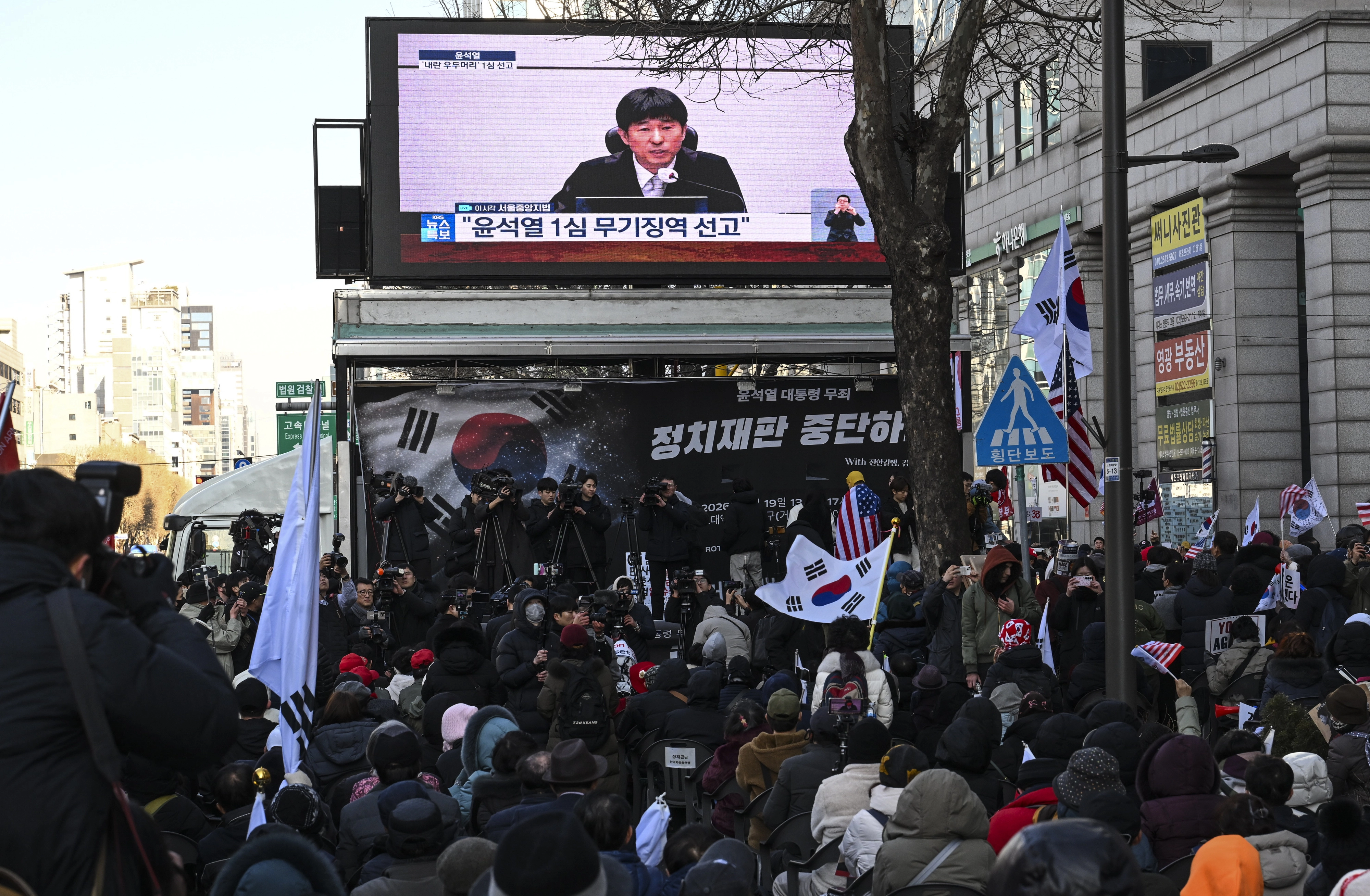 윤석열 전 대통령 지지자들이 19일 서울 서초구 서울중앙지법 인근에서 열린 무죄 선고 촉구 집회에서 윤 전 대통령에 대한 1심 선고공판 생중계를 시청하고 있다. 2026.2.19 이지훈 기자