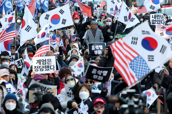 내란 우두머리 혐의로 기소된 윤석열 전 대통령의 1심 선고가 열리는 19일 서울 서초구 서울중앙지방법원 인근에서 지지자들이 손팻말을 들고 있다. 2026.2.19  연합뉴스