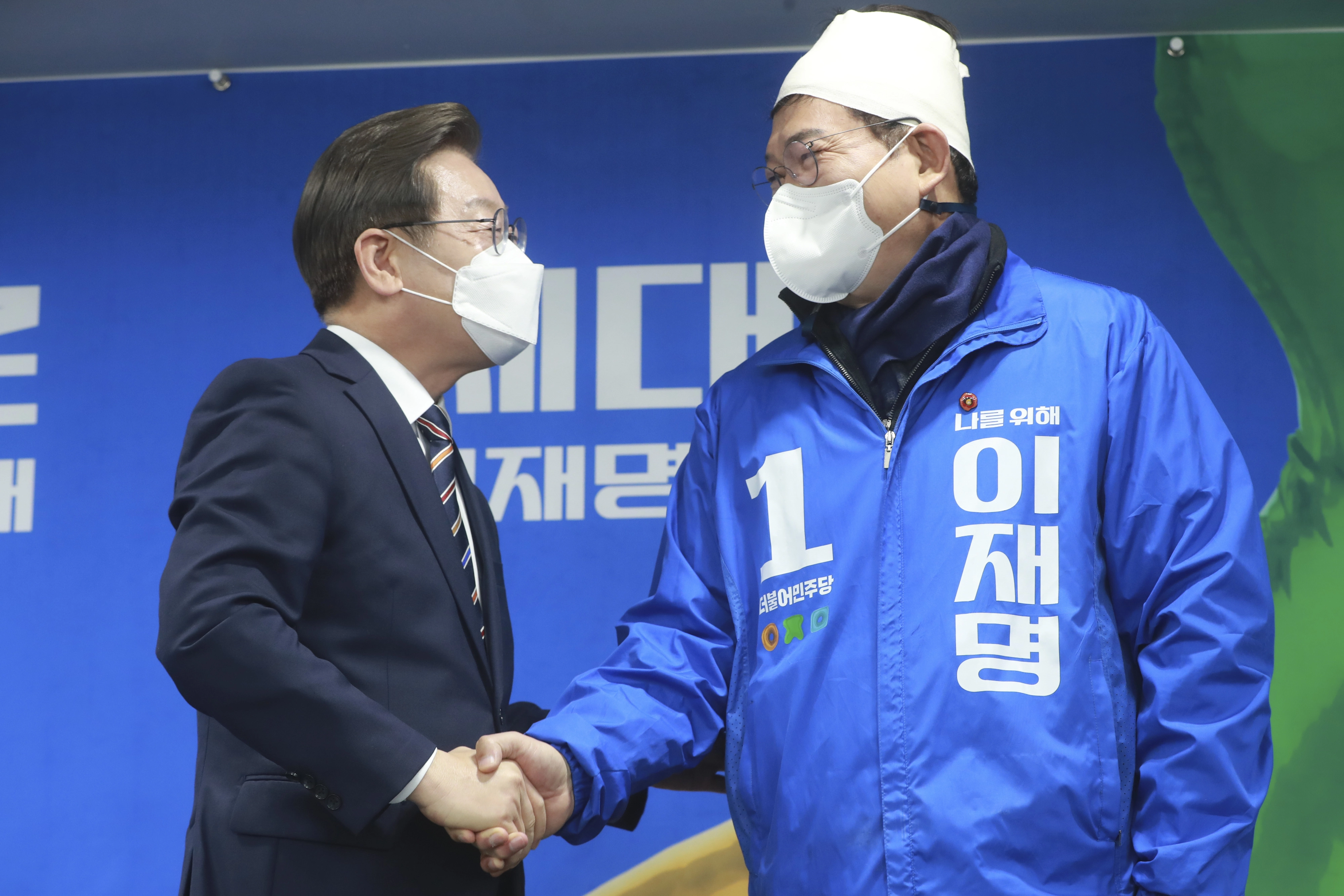 정치-제20대 대통령선거-송영길-더불어민주당 대표-망치 피습 후 붕대-회의 참석  더불어민주당 이재명 대선 후보가 8일 서울 여의도 당사에서 열린 위기 극복ㆍ국민통합 특별 기자회견에서 전날 선거운동 중 괴한에게 둔기 피습을 당한 송영길 대표의 손을 꼭 잡고 대화하고 있다. 2022.3.8 [국회 사진기자단]