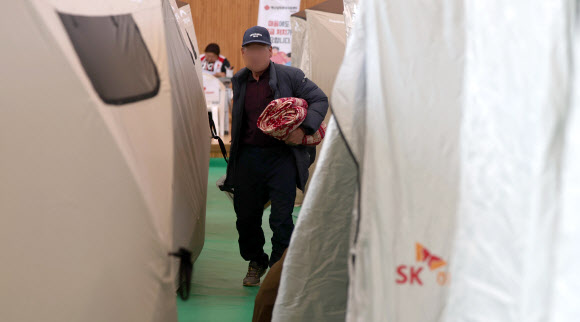 23일 경남 함양군 유림면 유림어울림체육관에 마련된 함양 산불 이재민 대피소에서 이재민이 담요 등을 들고 이동하고 있다. 2026.2.23  연합뉴스