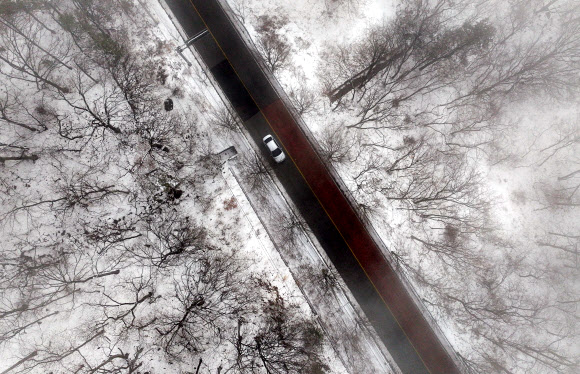 25일 경북 칠곡군 석적읍 국립 칠곡 숲체원 인근 도로에서 전날 내린 폭설 사이로 차량이 지나가고 있다. 2026.2.25  연합뉴스