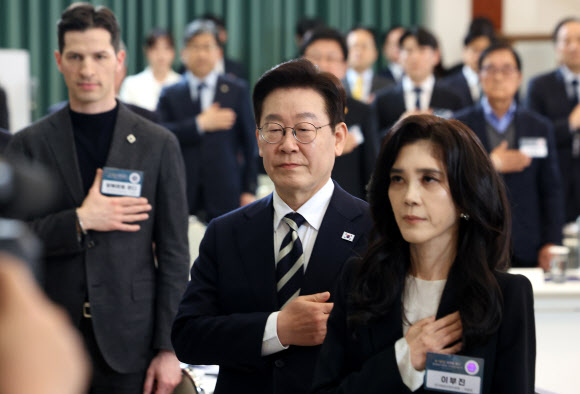 이재명 대통령이 25일 청와대에서 열린 확대국가관광전략회의에서 국기에 경례하고 있다.  오른쪽부터 이부진 한국방문의해위원장, 이 대통령, 알베르토 몬디 주한이탈리아 상공회의소 부회장. 2026.2.25. 연합뉴스