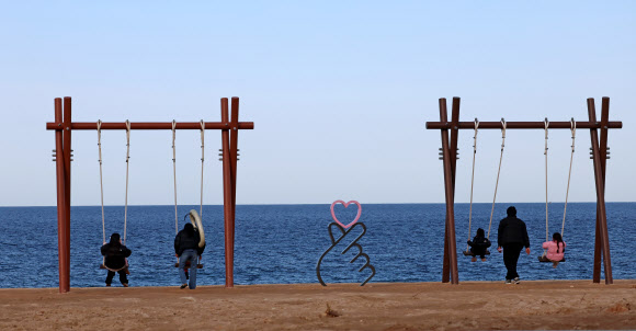 25일 강원 강릉시 사근진해변에서 한 가족이 그네를 타며 몸기운을 만끽하고 있다. 2026.2.25 연합뉴스