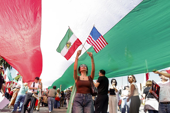 28일(현지시간) 미국 캘리포니아주 로스앤젤레스에서 미국과 이스라엘의 이란 공습 이후 시위대가 깃발을 흔들고 있다. EPA 연합뉴스