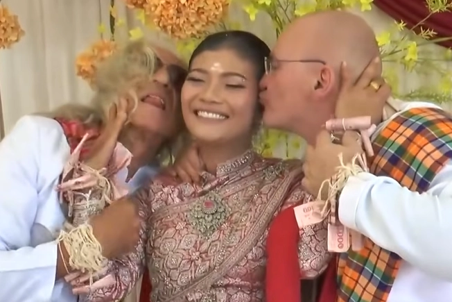 지난달 28일(현지시간) 태국 동부 부리람주의 한 마을에서 37세 여성과 오스트리아 출신 남성 2명의 결혼식이 열려 화제가 됐다. 사진은 전통 혼례로 치러진 이날 결혼식에서 행복해하는 신부와 두 신랑. 아마린TV 보도화면 캡처