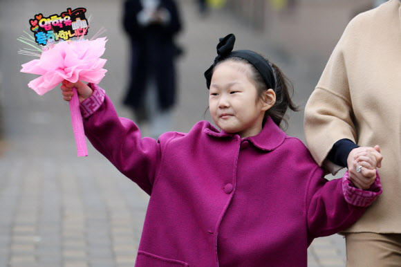 3일 입학식이 열린 서울 서초구 원촌초등학교에서 한 신입생이 입학 축하 꽃다발을 들고 등교하고 있다. 2026.3.3 연합뉴스