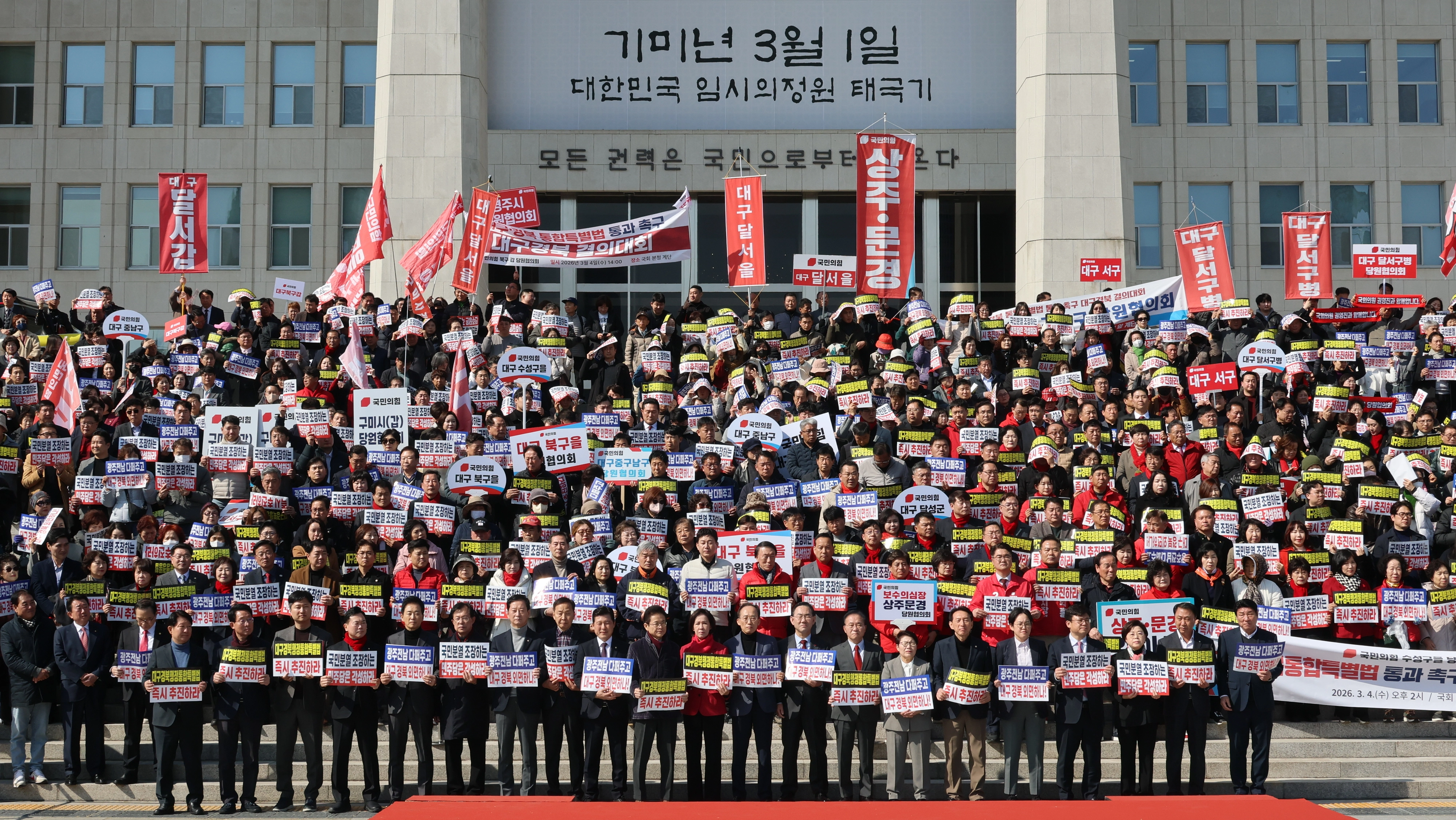 대구·경북 행정통합 촉구 결의대회  4일 서울 여의도 국회 본관 앞 계단에서 열린 ‘대구경북행정통합특별법 통과 촉구 대구·경북 결의대회’에서 손팻말을 들고 구호를 외치고 있다. 2026.3.4. 연합뉴스