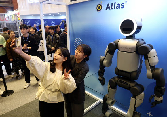 4일 코엑스에서 열린 2026 스마트공장·자동화산업전에서 모델들이 현대글로비스 아틀라스와 기념촬영을 하고 있다. 2026.3.4 연합뉴스