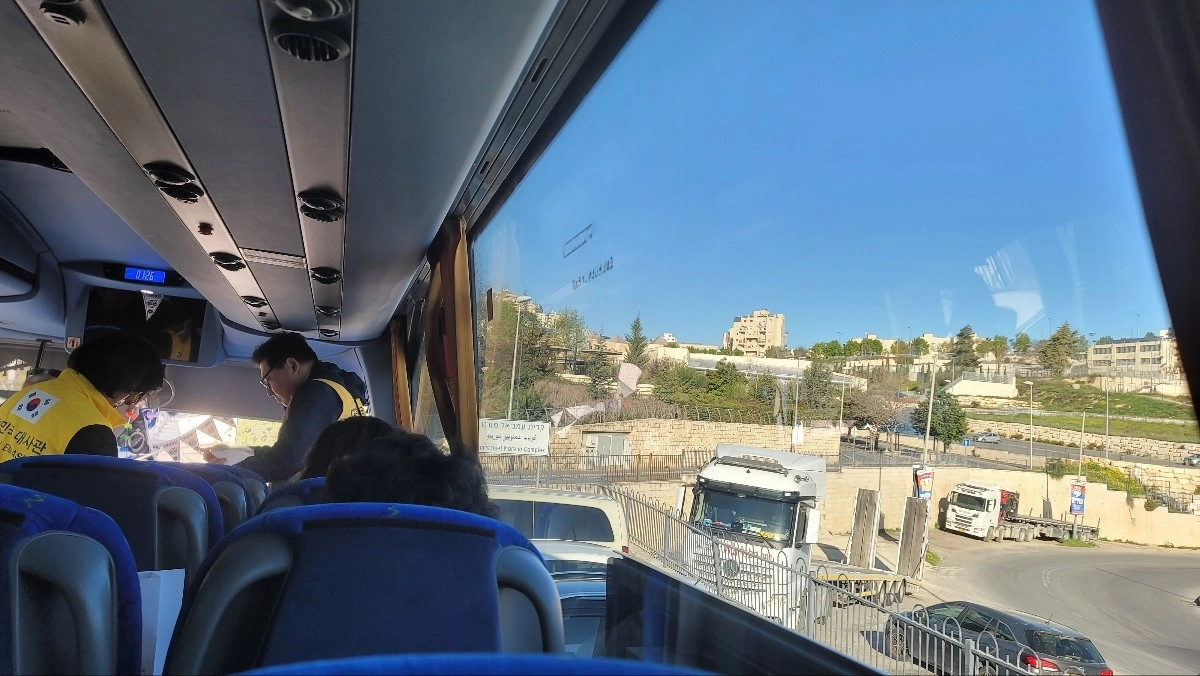 윤정태씨 등 한국인 113명이 3일 주이스라엘 한국 대사관이 제공한 버스를 타고 예루살렘을 떠나 이집트에 들어서고 있다. 앞쪽엔 노란 조끼를 입은 대사관 직원들이 분주하게 움직이는 모습. 본인 제공